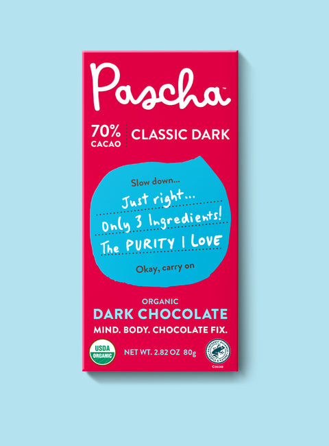 The front of Pascha Chocolate's 70% Classic Dark Chocolate Bar with half of the exposed bar sticking out of the top of the packaging