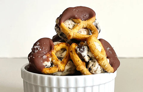 Cookie dough pretzel bites are sitting in a white small bowl