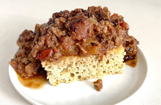 chocolate chili spooned over gluten-free bread on a white plate