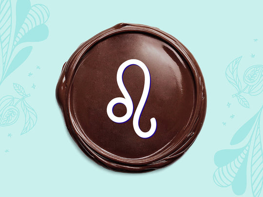 White Leo sign on a disc of melted dark chocolate on a light teal background.