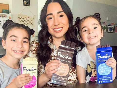 Mom and two young daughters each holding a bar of pascha chocolate