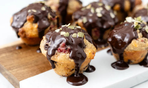 melted chocolate and pumpkin seeds on mini raspberry muffins