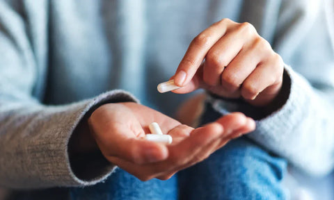 Hands holding white pills