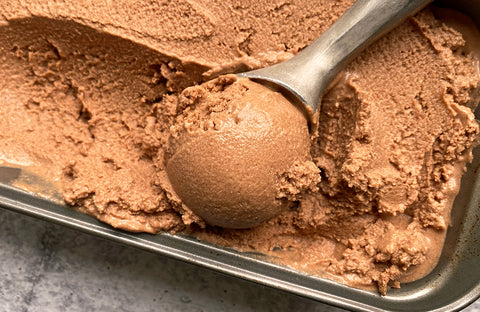 Scoop of chocolate paleo ice cream recipe in a metal container.