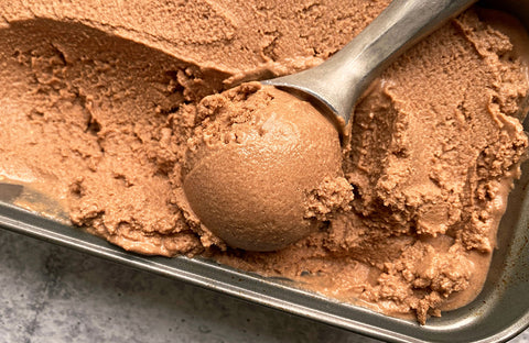Scoop of chocolate paleo ice cream recipe in a metal container.