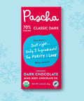 The front of Pascha Chocolate's 70% Classic Dark Chocolate Bar with half of the exposed bar sticking out of the top of the packaging