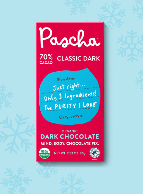 The front of Pascha Chocolate's 70% Classic Dark Chocolate Bar with half of the exposed bar sticking out of the top of the packaging