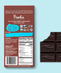 The back of Pascha chocolate's 55% cacao with cocoa nibs dark chocolate bar and bar of chocolate with bite taken out.