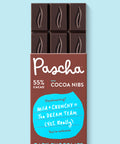 The front of Pascha Chocolate's 55% with Cocoa Nibs Dark Chocolate Bar with half of the exposed bar sticking out of the top of the packaging