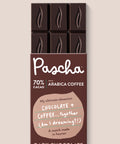 The front of Pascha Chocolate's 70% with arabica coffee Dark Chocolate Bar with half of the exposed bar sticking out of the top of the packaging