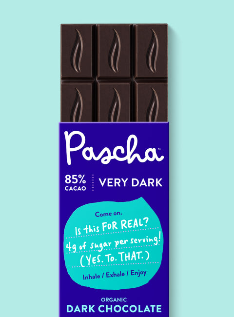 The front of Pascha Chocolate's 85% with Very Dark Chocolate Bar with half of the exposed bar sticking out of the top of the packaging