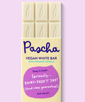 The front of Pascha Chocolate's Vegan White Bar with half of the exposed bar sticking out of the top of the packaging