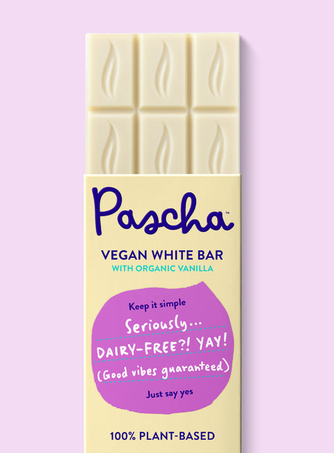 The front of Pascha Chocolate's Vegan White Bar with half of the exposed bar sticking out of the top of the packaging