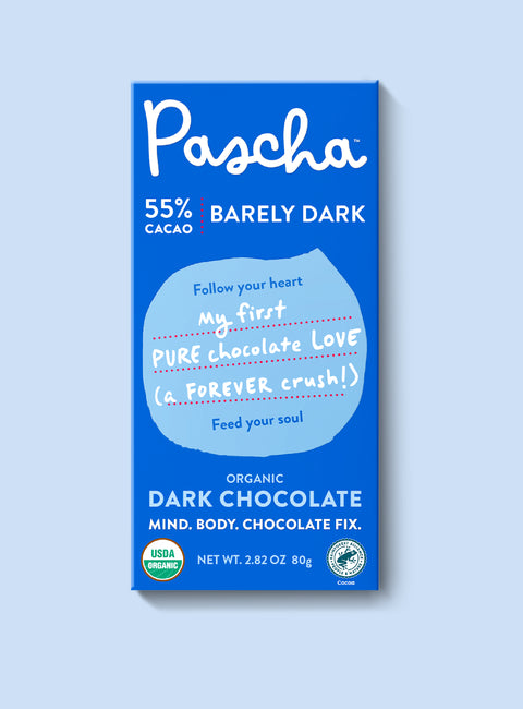 The front of Pascha Chocolate's 55% Barely Dark Chocolate Bar with half of the exposed bar sticking out of the top of the packaging