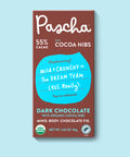 The front of Pascha Chocolate's 55% with Cocoa Nibs Dark Chocolate Bar with half of the exposed bar sticking out of the top of the packaging