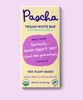 The front of Pascha Chocolate's Vegan White Bar with half of the exposed bar sticking out of the top of the packaging