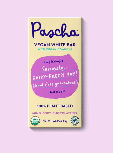 The front of Pascha Chocolate's Vegan White Bar with half of the exposed bar sticking out of the top of the packaging