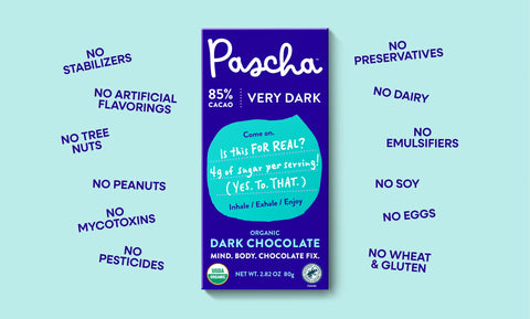 Pascha 85% Very Dark Chocolate Bar rests in the middle on a teal background with words surrounding the bar. Starting top left - No Stabilizers, No Artificial Flavorings, No Tree Nuts, No Peanuts, No Mycotoxins, No Pesticides, No Preservatives, No Dairy, No Emulsifiers, No Soy, No Eggs, No Wheat & Gluten 