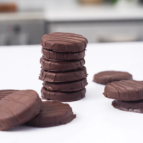Stack of chocolate cookies on a white surface with a blurred background